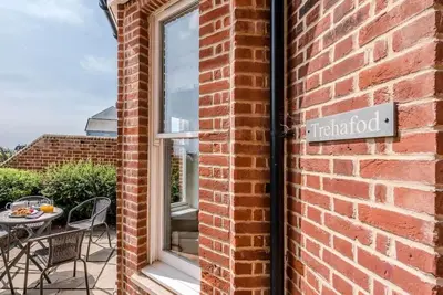 a brick wall with a sign on the side of a building at Trehafod, Aldeburgh in Aldeburgh