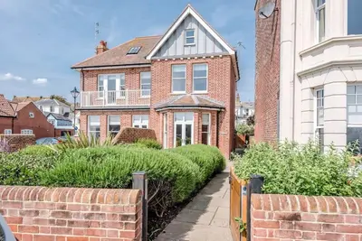 a brick house with a brick fence in front of it at Trehafod, Aldeburgh in Aldeburgh