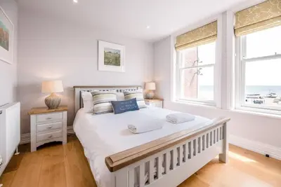 a bedroom with a large white bed and two windows at Trehafod, Aldeburgh in Aldeburgh