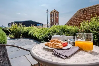 a table with a plate of bread and orange juice at Trehafod, Aldeburgh in Aldeburgh