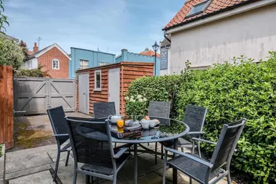 a patio with a table and chairs in a backyard at Lyndhurst, Aldeburgh in Aldeburgh