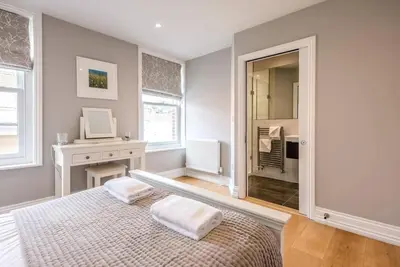 a bedroom with a bed and a desk and a mirror at Lyndhurst, Aldeburgh in Aldeburgh