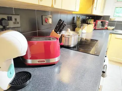 a red toaster sitting on top of a kitchen counter at 2 Single Beds, 1 BR Apartment in Newmarket