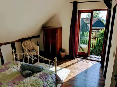 a bedroom with a bed and a door to a balcony at Stunning barn conversion ideal for large families in Bildeston