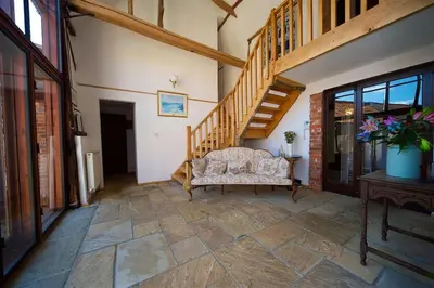 a living room with a couch and a staircase at Stunning barn conversion ideal for large families in Bildeston