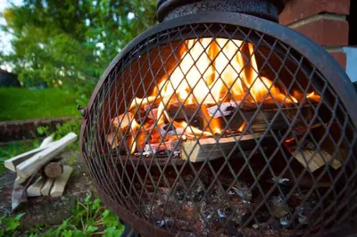 a grill with a fire inside of it at Stunning barn conversion ideal for large families in Bildeston