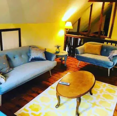 a living room with a blue couch and a table at Stunning barn conversion ideal for large families in Bildeston