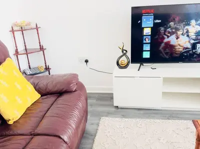 a living room with a couch and a flat screen tv at Tranquil Haven: 3-BR House in Great Burstead
