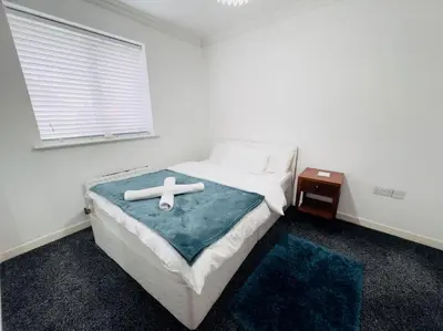 a bedroom with a bed with a cross on it at Tranquil Haven: 3-BR House in Great Burstead