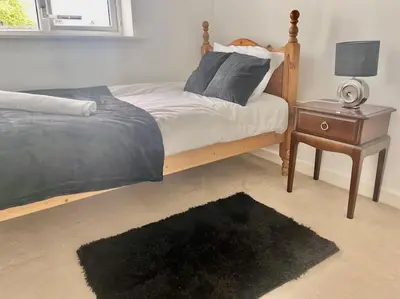 a bedroom with a bed and a nightstand and a bed sidx sidx at Tranquil Haven: 3-BR House in Great Burstead