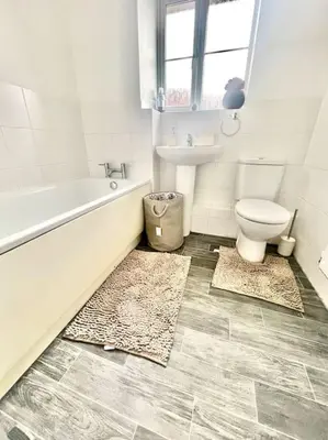 a bathroom with a tub and a toilet and a sink at Tranquil Haven: 3-BR House in Great Burstead