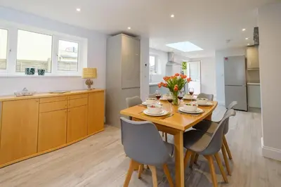 a kitchen and dining room with a wooden table and chairs at Primrose Cottage, Leiston, near Sizewell, Thorpeness and Aldeburgh - Managed by Aldeburgh Coastal Cottages in Leiston