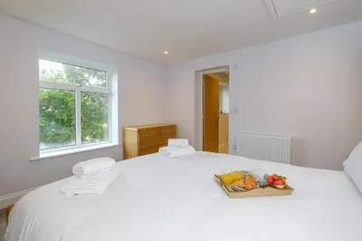 a white bed with a bowl of fruit on it at Primrose Cottage, Leiston, near Sizewell, Thorpeness and Aldeburgh - Managed by Aldeburgh Coastal Cottages in Leiston