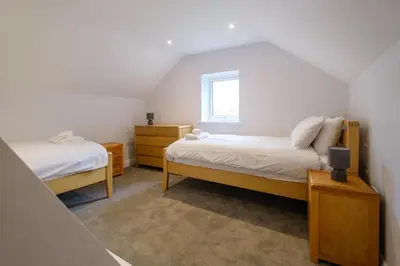 a bedroom with two beds and a window at Primrose Cottage, Leiston, near Sizewell, Thorpeness and Aldeburgh - Managed by Aldeburgh Coastal Cottages in Leiston