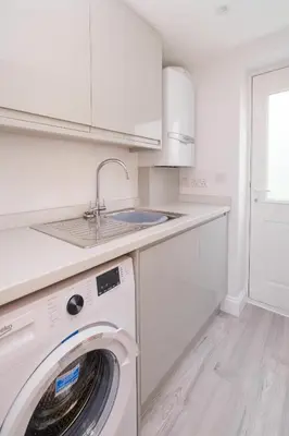 a white kitchen with a washing machine and a sink at Primrose Cottage, Leiston, near Sizewell, Thorpeness and Aldeburgh - Managed by Aldeburgh Coastal Cottages in Leiston