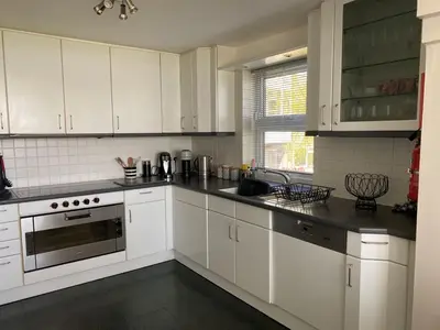 a white kitchen with white cabinets and a sink at La de da Frinton on Sea in Frinton-on-Sea
