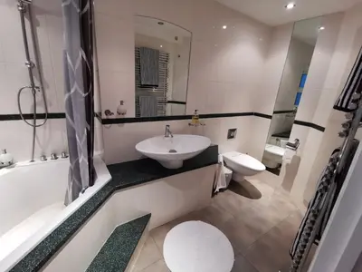 a bathroom with a sink and a tub and a toilet at La de da Frinton on Sea in Frinton-on-Sea