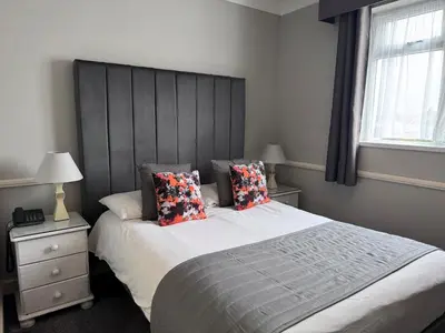 a bedroom with a large bed with two pillows at Camelia Hotel in Southend-on-Sea
