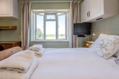 a bedroom with a large white bed with a window at Number 27, Alderton in Woodbridge