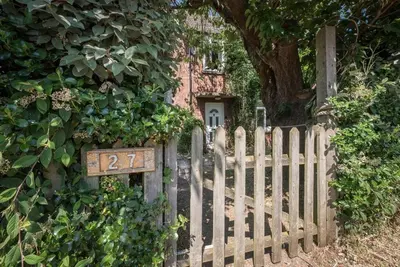 a wooden fence with a sign in front of a house at Number 27, Alderton in Woodbridge
