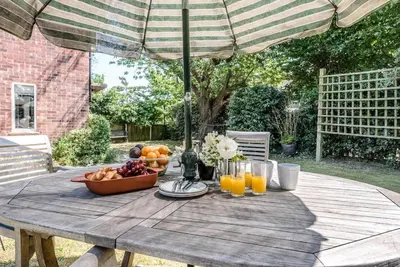 a picnic table with a bowl of fruit and an umbrella at Number 27, Alderton in Woodbridge