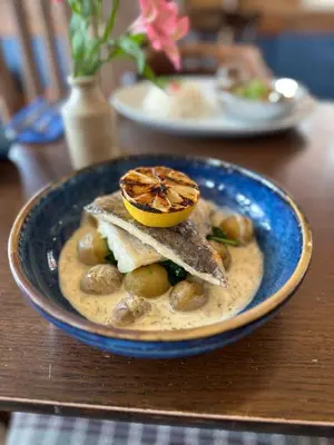 a blue bowl of food with an orange on top at The Crown Pub and Hotel in Manningtree