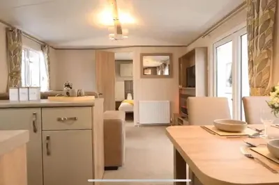a kitchen and living room with a table and chairs at Rohannah Luxe Coastal Escape, Cooper Beach East Mersea in East Mersea