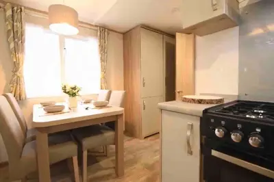 a small kitchen with a table and a stove at Rohannah Luxe Coastal Escape, Cooper Beach East Mersea in East Mersea