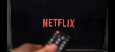 a person holding a remote control in front of a tv at 5 Bedroom House - DISC0UNTS - Parking, Contractors, Group, Family in Braintree