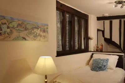 a bedroom with a bed with a lamp and a painting at Colston Hall Farmhouse B&B in Framlingham