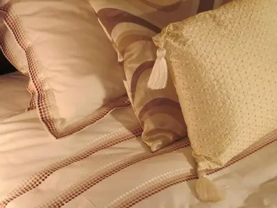 a bed with two pillows and a pillow with a tassel at Colston Hall Farmhouse B&B in Framlingham