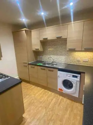 a kitchen with a stove and a washing machine at Colchester Smart Two Bed Apartment in Colchester
