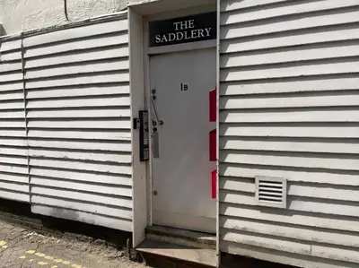 a white door with a sign on the side of a building at SmithStayz Apartments Epping in Epping