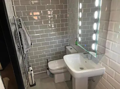 a white bathroom with a sink and a toilet at SmithStayz Apartments Epping in Epping