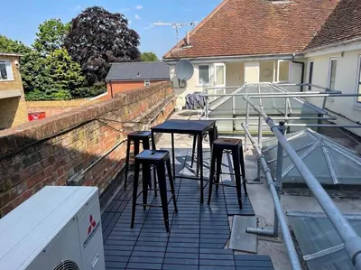 a table and stools on the roof of a house at SmithStayz Apartments Epping in Epping