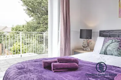 a bedroom with a purple bed with a large window at Purple Velvet - 2 Bed Home Spacious - Basildon Essex Upto 5 Guests, Free Wifi , Free Parking in Basildon