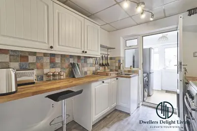 a kitchen with white cabinets and a large window at Purple Velvet - 2 Bed Home Spacious - Basildon Essex Upto 5 Guests, Free Wifi , Free Parking in Basildon