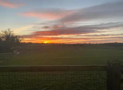 a sunset in a field with a fence at Near Woodbridge The Annexe Eyke Fantastic views with Dog secure Garden and Paddock in Eyke