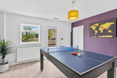 a blue ping pong table in a living room with at Pristine House - Sleeps 10 - Amazing Location in Ipswich