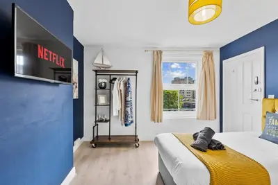 a bedroom with a bed and a tv on a wall at Pristine House - Sleeps 10 - Amazing Location in Ipswich