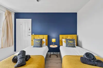 two beds sitting next to each other in a bedroom at Pristine House - Sleeps 10 - Amazing Location in Ipswich