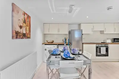a kitchen with a table with blue and white dishes on it at Pristine House - Sleeps 10 - Amazing Location in Ipswich