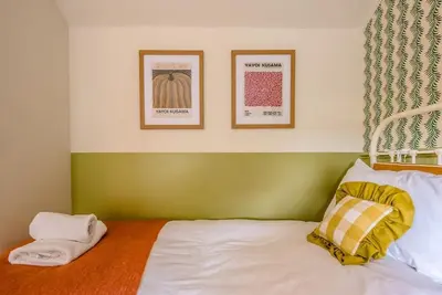 a bedroom with green and white walls and a bed at The Old Forge, Great Glemham in Great Glemham