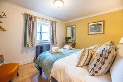 a bedroom with a bed with two towels on it at The Old Forge, Great Glemham in Great Glemham