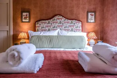 a bedroom with a large bed with towels on it at The Old Forge, Great Glemham in Great Glemham