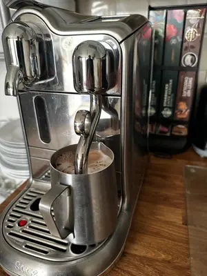a coffee machine with a coffee being poured into it at Chez Ana in Saxmundham