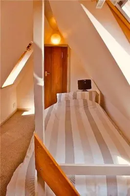 a bedroom with a bed in a attic at River Lark Lodge in Ely