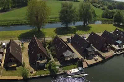 an aerial view of a house with a boat in the water at River Lark Lodge in Ely