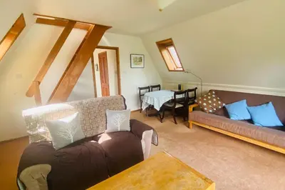 a living room with two couches and a table at River Lark Lodge in Ely