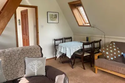 a living room with a table and a couch at River Lark Lodge in Ely
